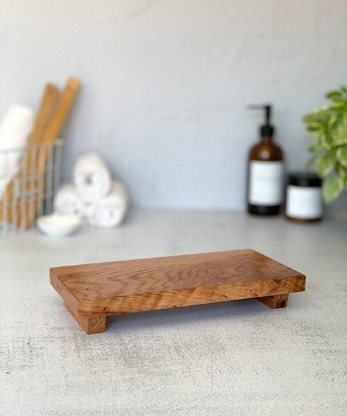 A small countertop tray (wood, metal, or stone-look)